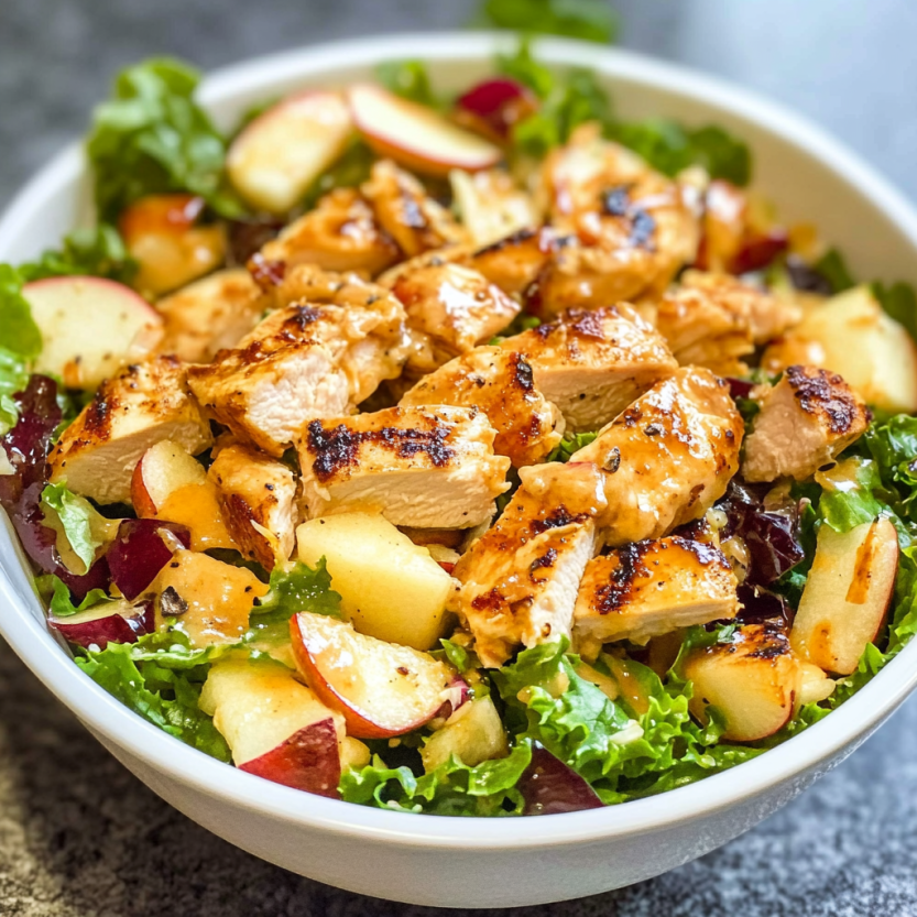 Une salade composée d'épinards, d'apples, de cheddar blanc et de poulet grillé.