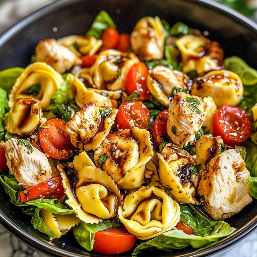 Une salade de tortellini chaude avec des légumes et du poulet.