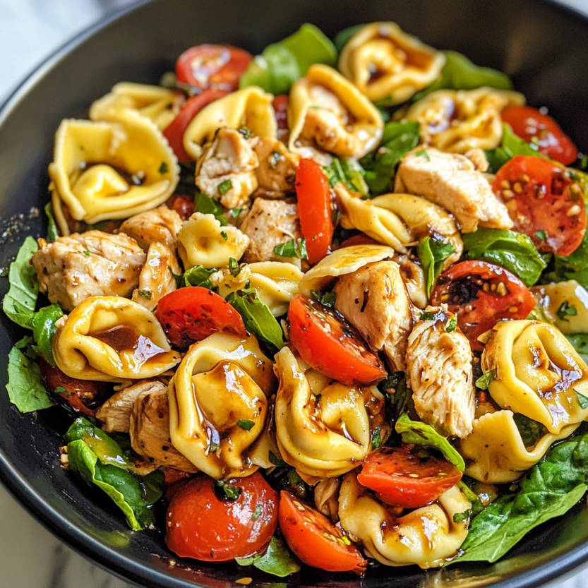 Une salade de tortellini chaude avec des légumes et du poulet.