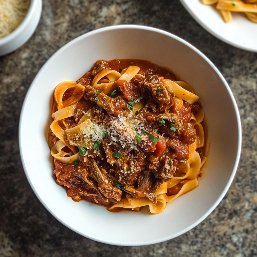 Une assiette de spaghetti bolognaise avec des herbes et des tomates.
