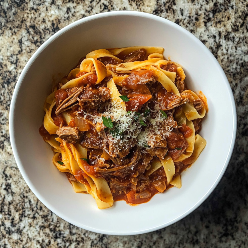 Une assiette de spaghetti bolognaise avec des herbes et des tomates.