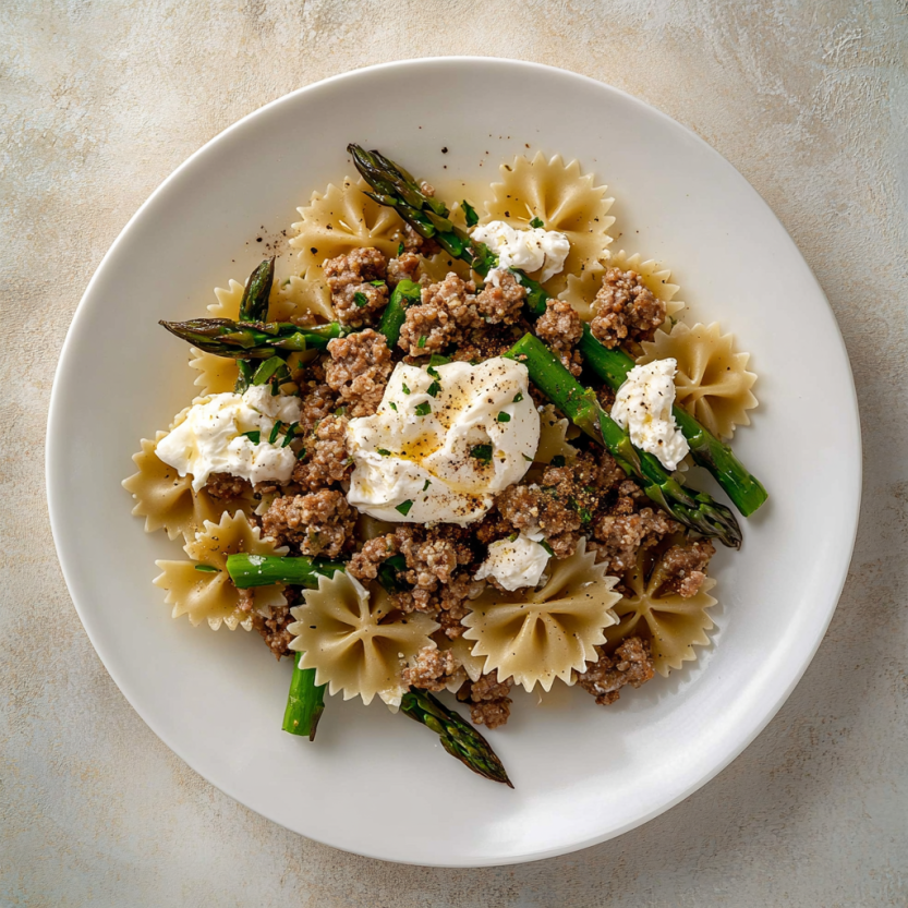 Une assiette de crispy sausage et d'asperges farfalle avec burrata.