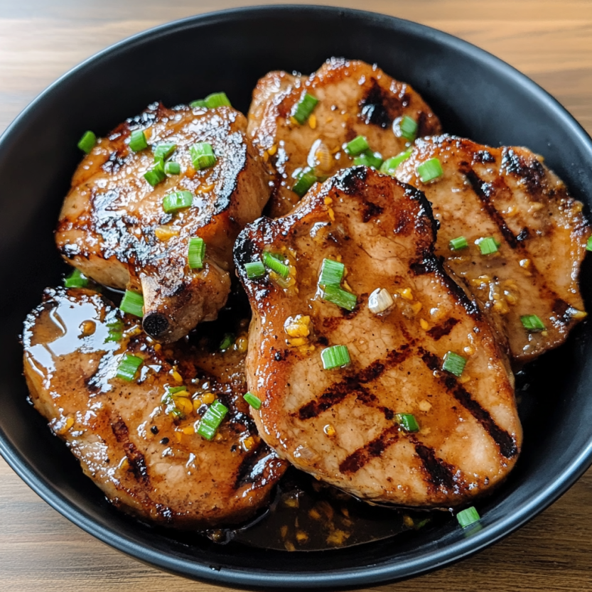 A bowl of juicy grilled pork chops with spicy peach glaze.