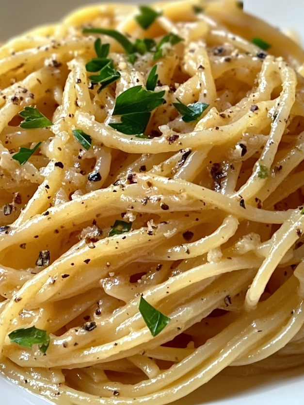 A plate of pasta with a green herb on top.