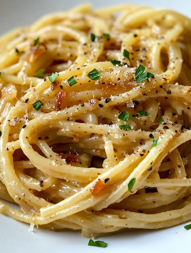 A plate of pasta with caramelized onions.
