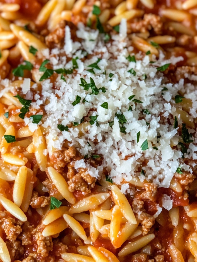 A dish of ground turkey orzo in tomato sauce.